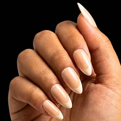 French Whisper press-on nail set - short almond nails with sheer pink base and subtle white French tips, dorsal view