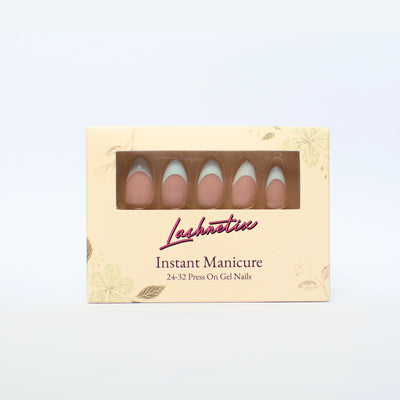 A box of Lashnetix 'Instant Manicure' press-on nails against a white background. The packaging is cream-colored with gold floral sketches and displays short almond nude with sage green french tip nails through a clear window.
