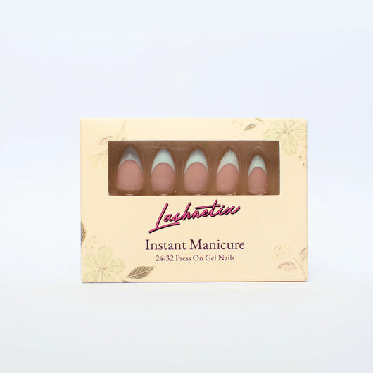 A box of Lashnetix 'Instant Manicure' press-on nails against a white background. The packaging is cream-colored with gold floral sketches and displays short almond nude with sage green french tip nails through a clear window.