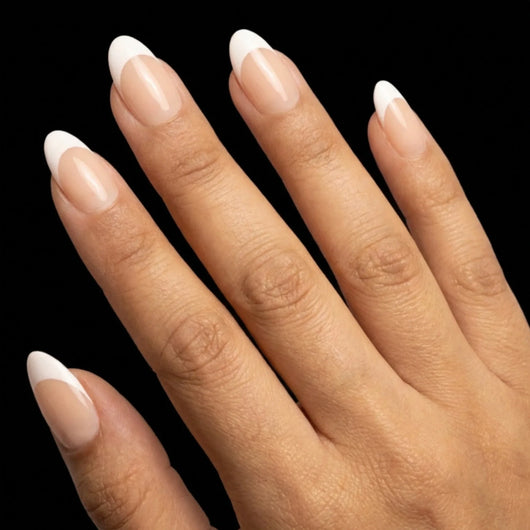 Short Oval in Nude French Tip press-on nails on medium skin tone - Soft French Instant Manicure.